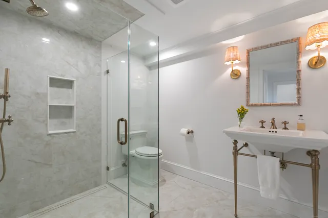 a bathroom with a sink a toilet and shower