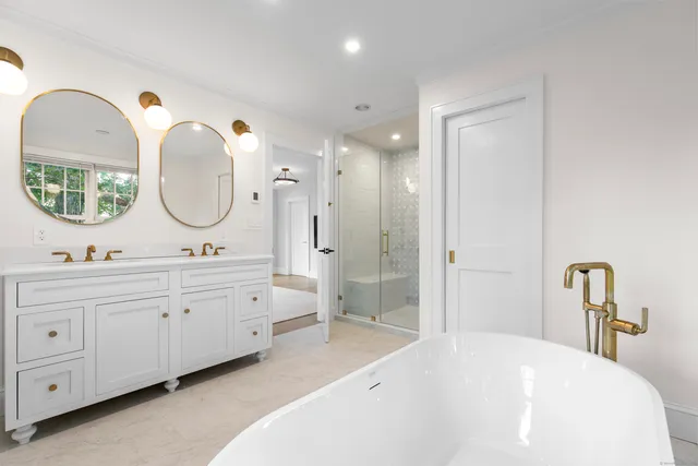 a spacious bathroom with a double vanity sink double mirror and shower