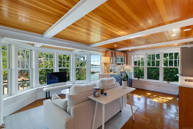 a living room with furniture floor to ceiling windows and a floor to ceiling window