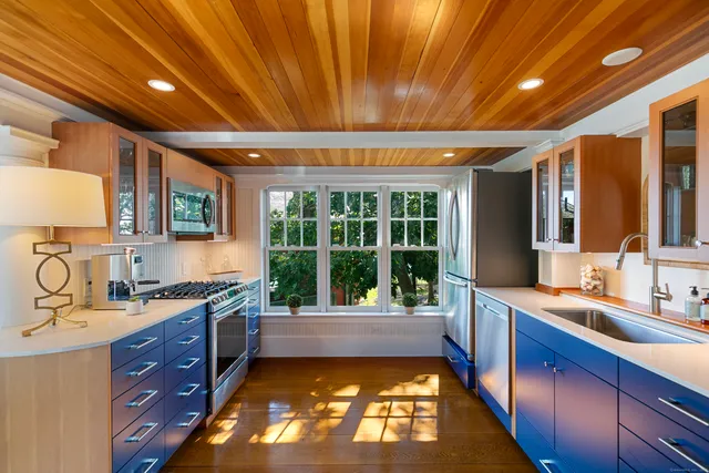 a large kitchen with kitchen island granite countertop a sink and a large window