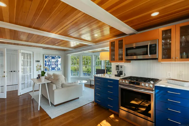 a living room with furniture a flat screen tv and kitchen view