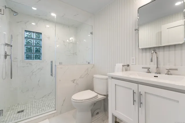 a bathroom with a sink a toilet and shower