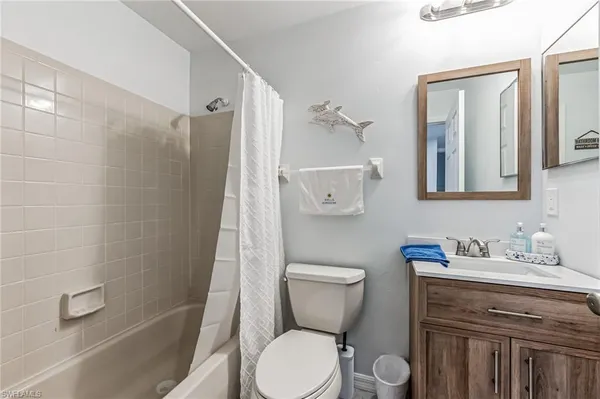 a bathroom with a toilet sink vanity and shower