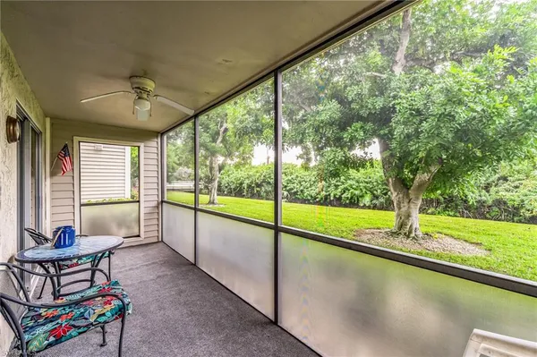 a living room with furniture and a floor to ceiling window