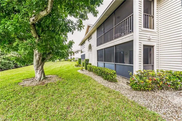 a view of an house with backyard and a tree