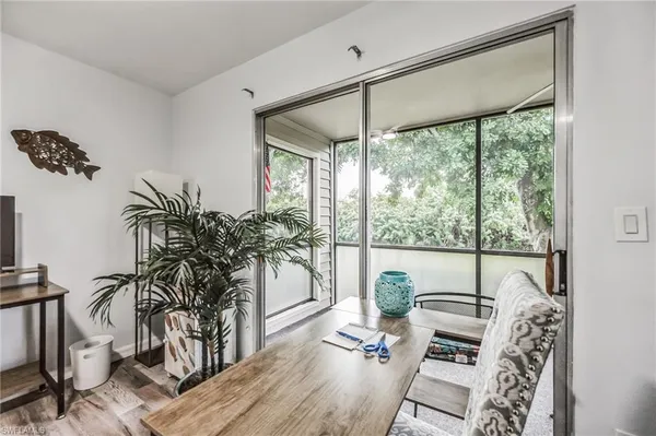 a living room with furniture large window and wooden floor