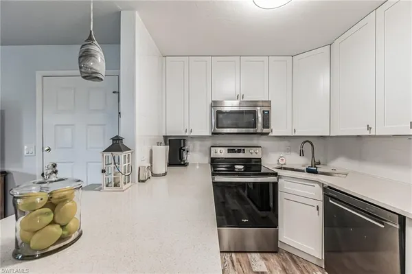a kitchen with stainless steel appliances white cabinets and a sink