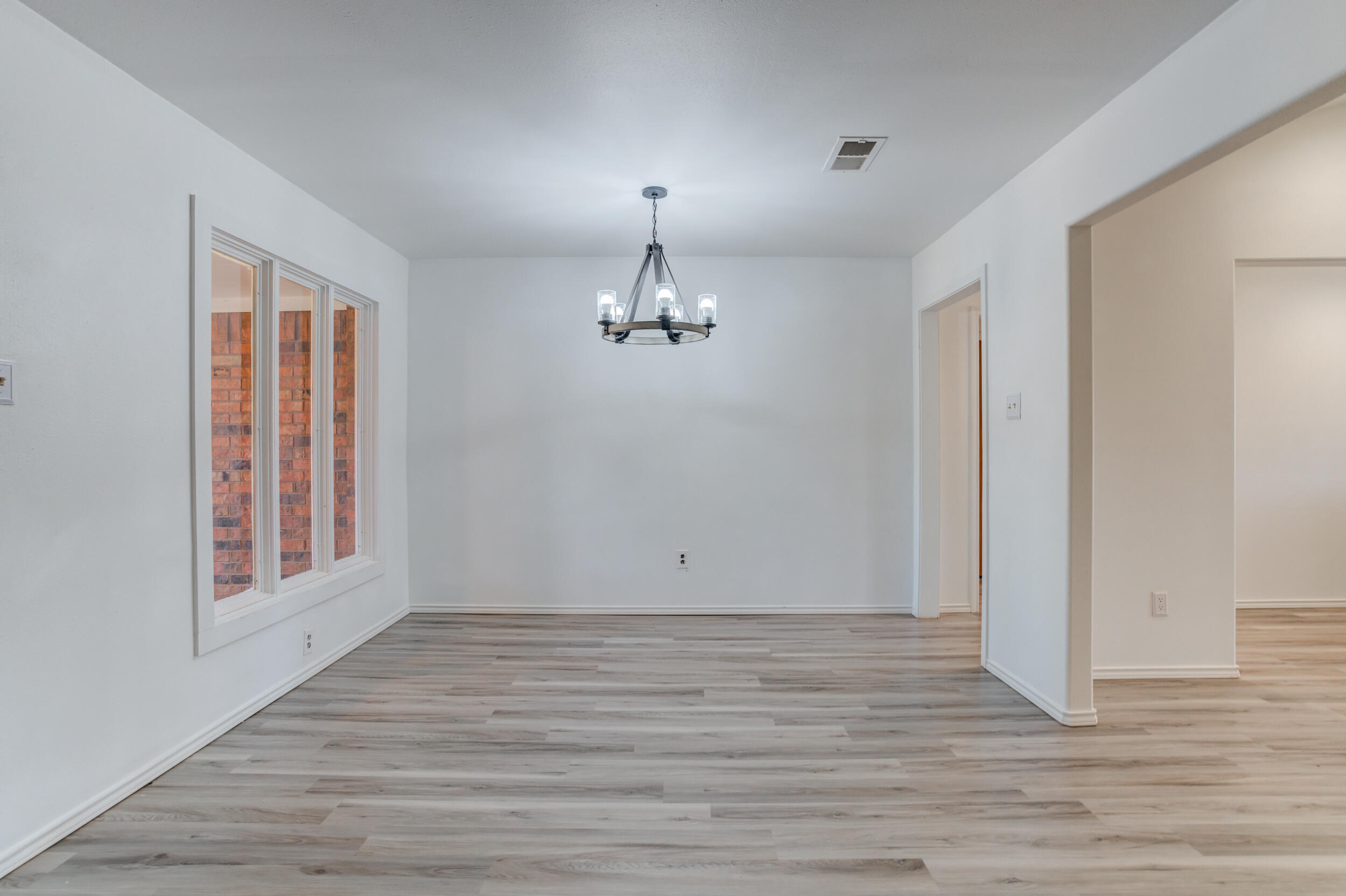 5504 73rd Street Lubbock, TX 79424 - Photo 12 of 39 wooden floor in an empty room with a window