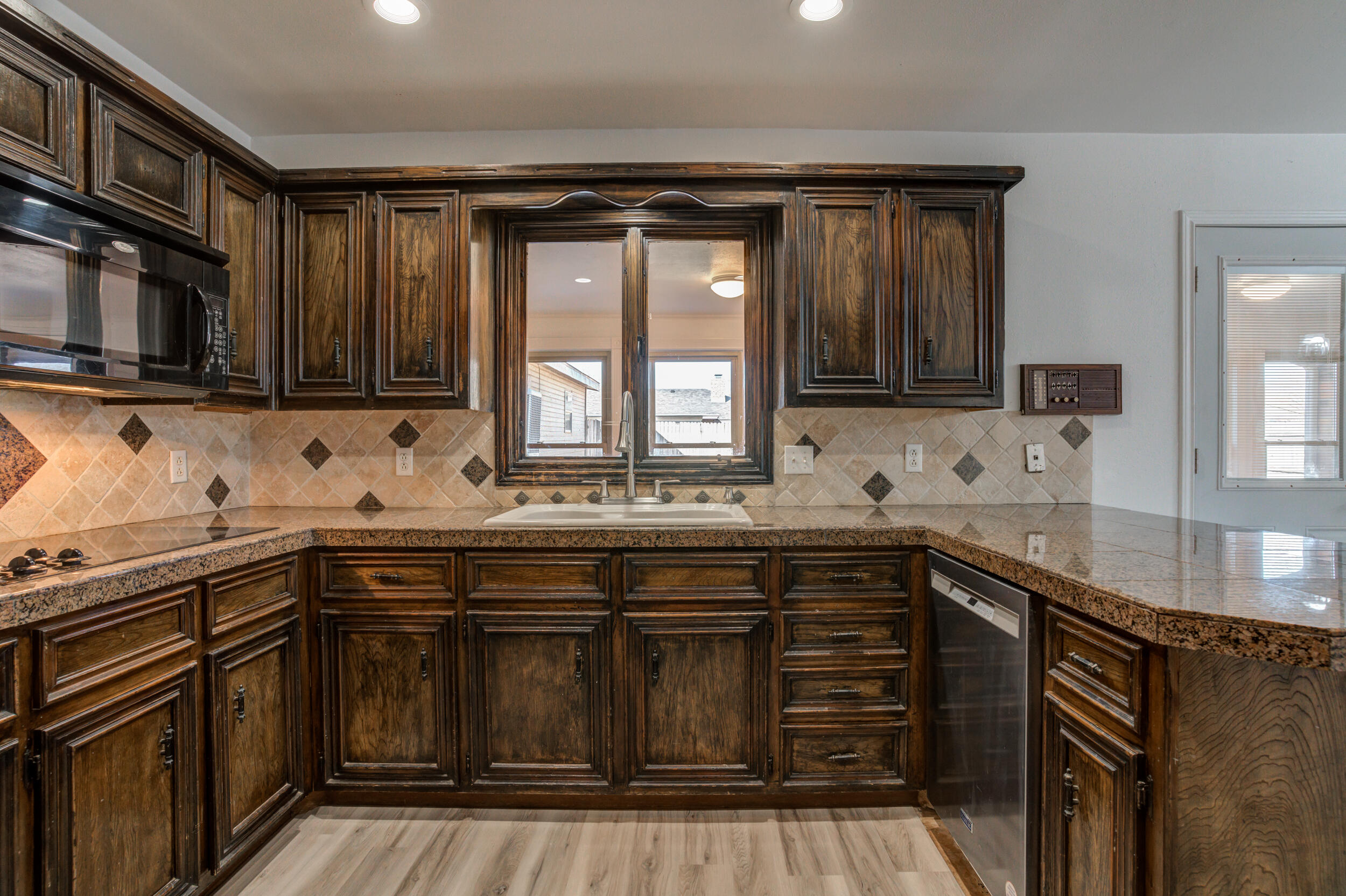 5504 73rd Street Lubbock, TX 79424 - Photo 16 of 39 a kitchen with granite countertop a sink and cabinets