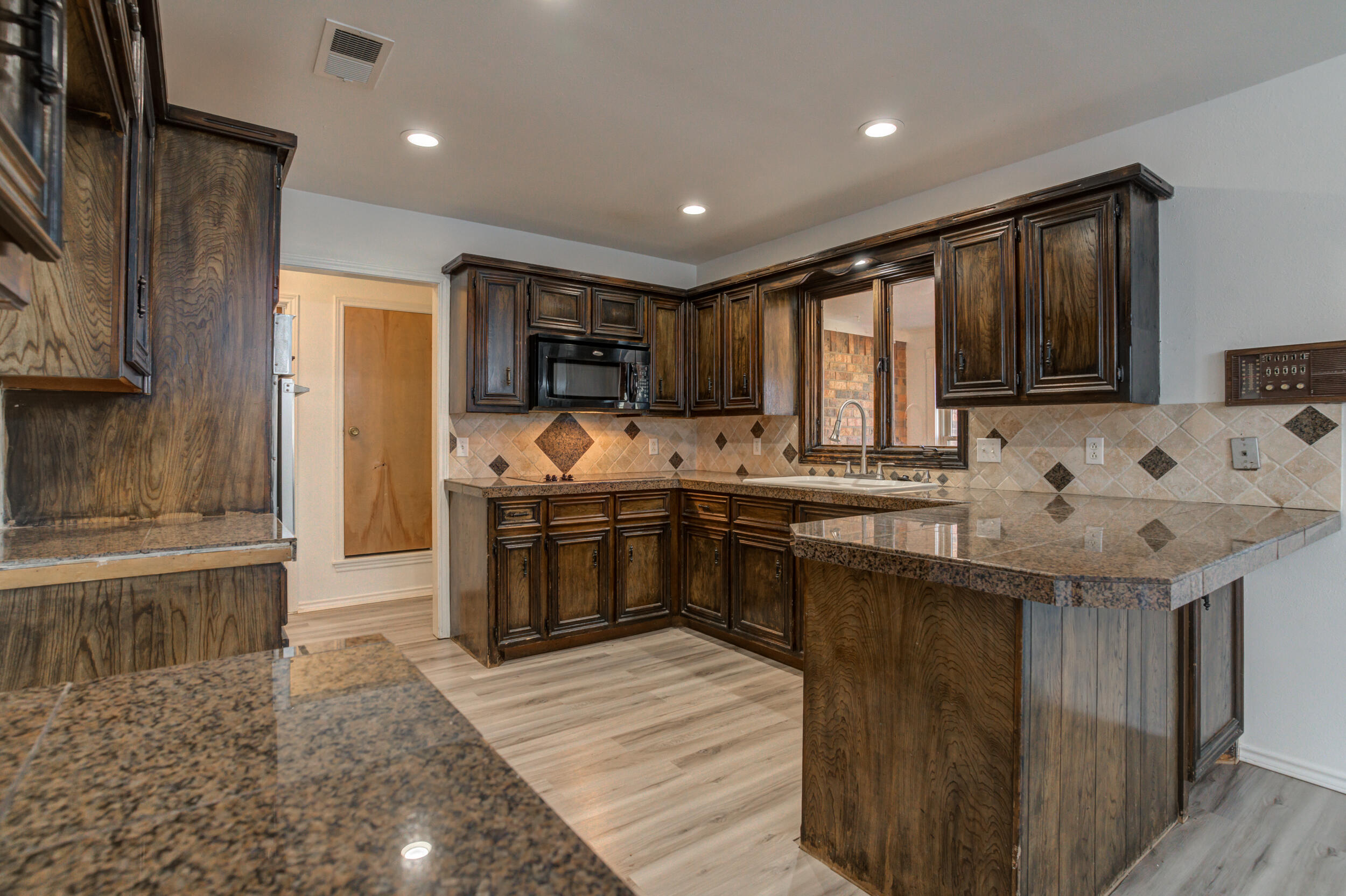 5504 73rd Street Lubbock, TX 79424 - Photo 18 of 39 a kitchen with stainless steel appliances granite countertop a sink stove and refrigerator