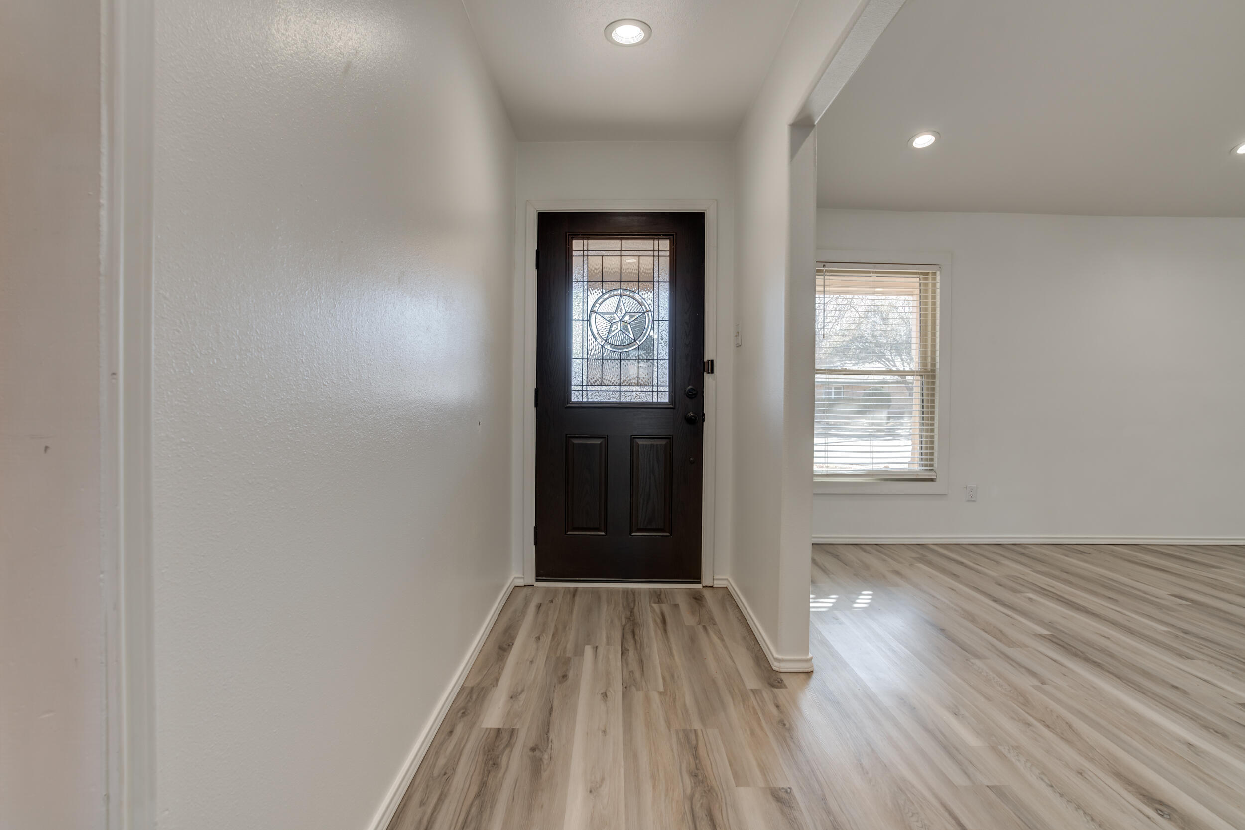 5504 73rd Street Lubbock, TX 79424 - Photo 3 of 39 a view of hallway with window and wooden floor