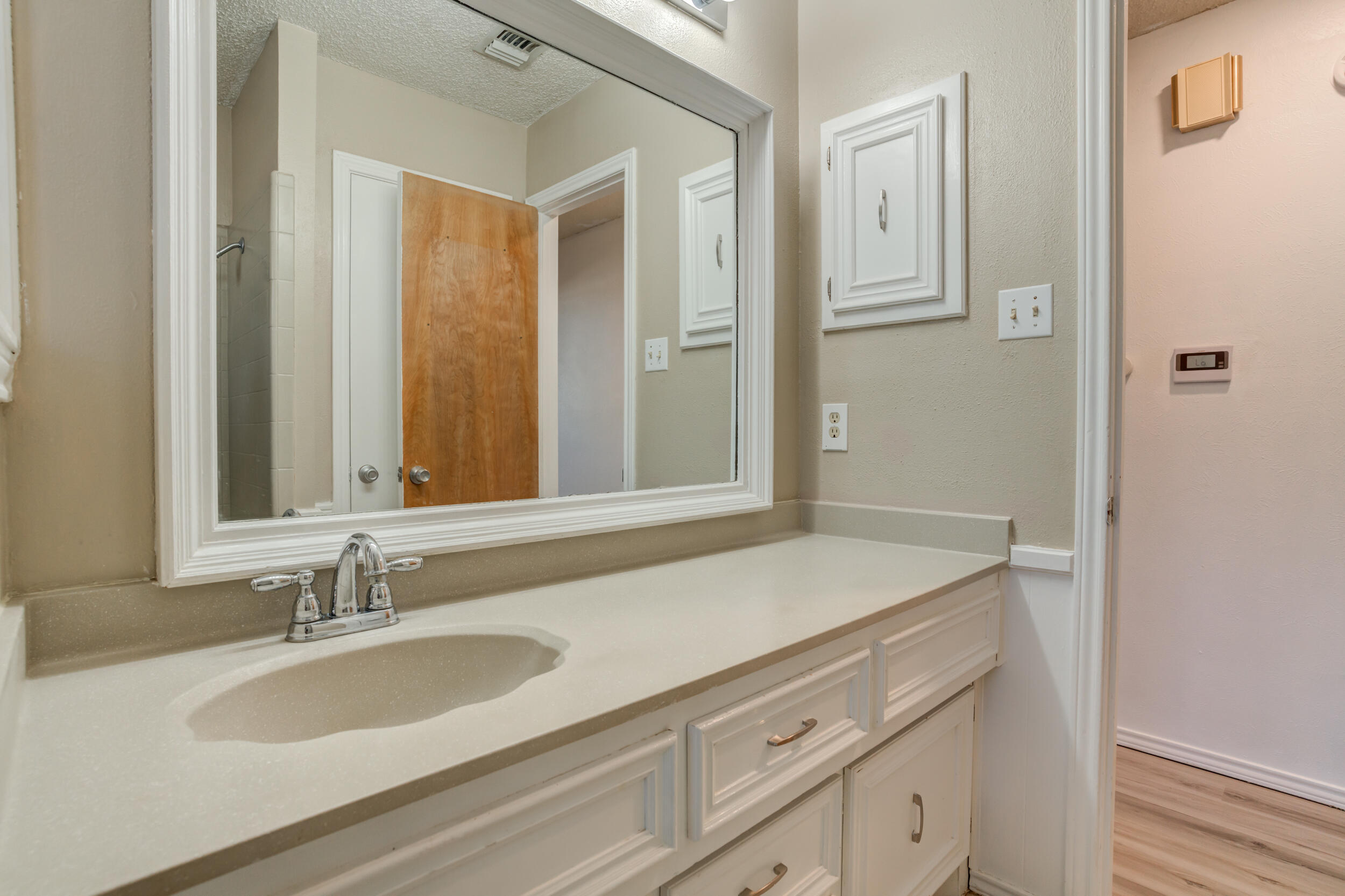 5504 73rd Street Lubbock, TX 79424 - Photo 33 of 39 a bathroom with a sink and a mirror