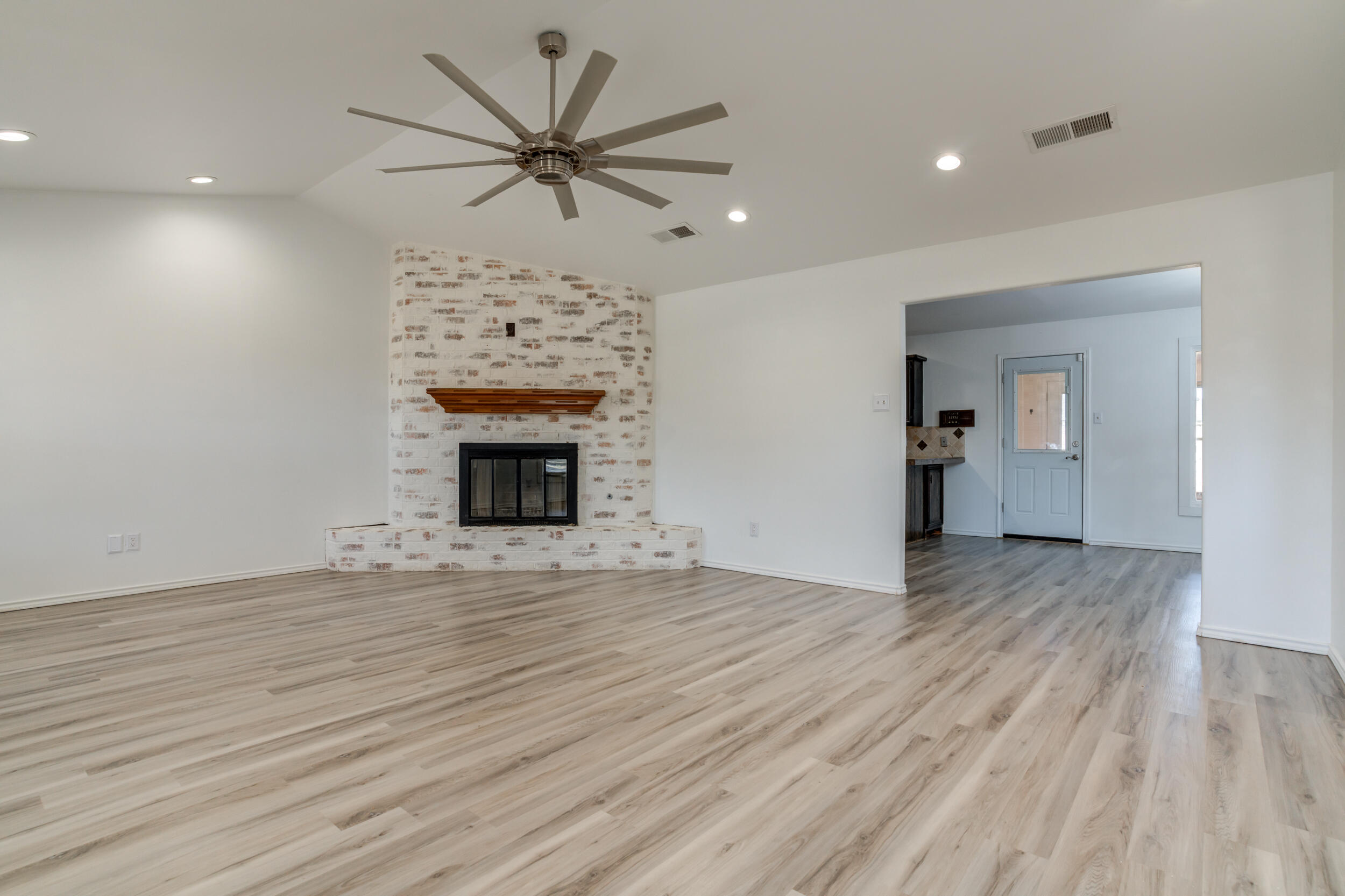 5504 73rd Street Lubbock, TX 79424 - Photo 4 of 39 a view of a livingroom with a fireplace a ceiling fan and wooden floor
