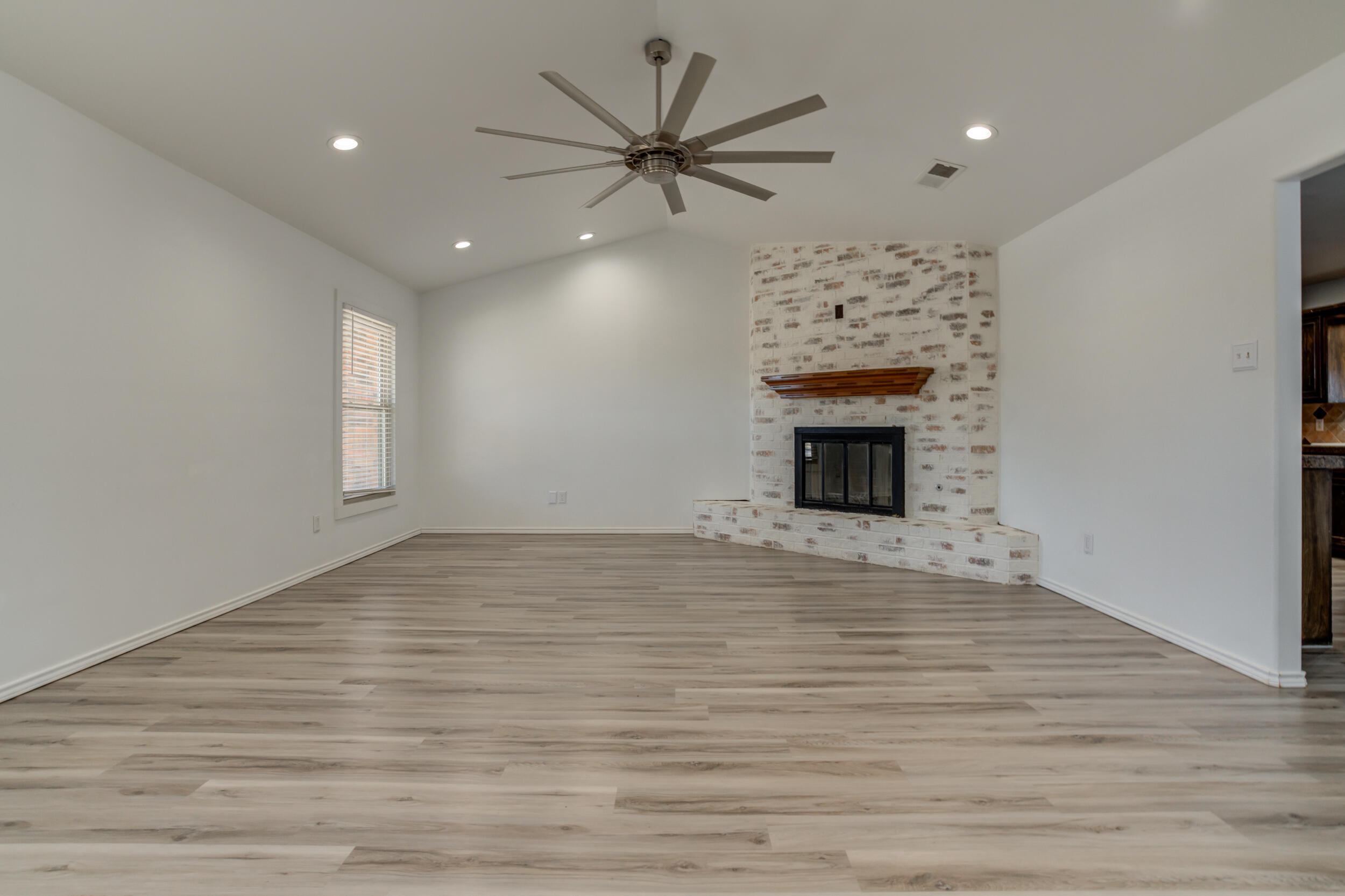 5504 73rd Street Lubbock, TX 79424 - Photo 5 of 39 wooden floor fireplace and windows in the room