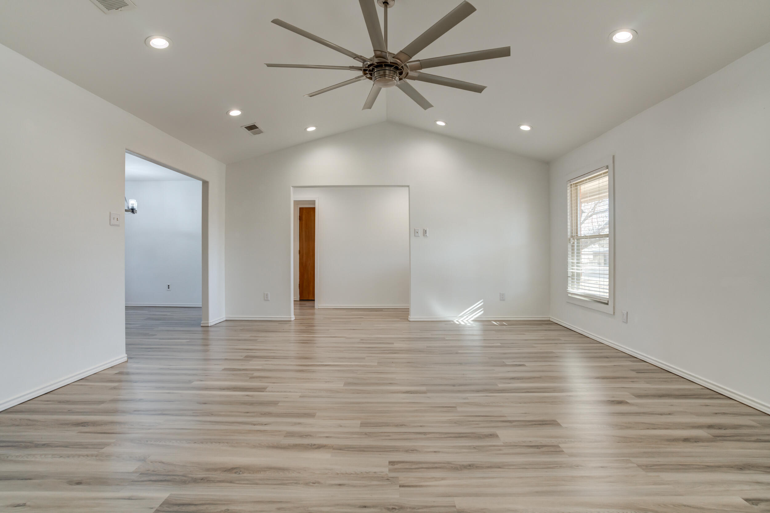 5504 73rd Street Lubbock, TX 79424 - Photo 8 of 39 a view of an empty room with window and wooden floor