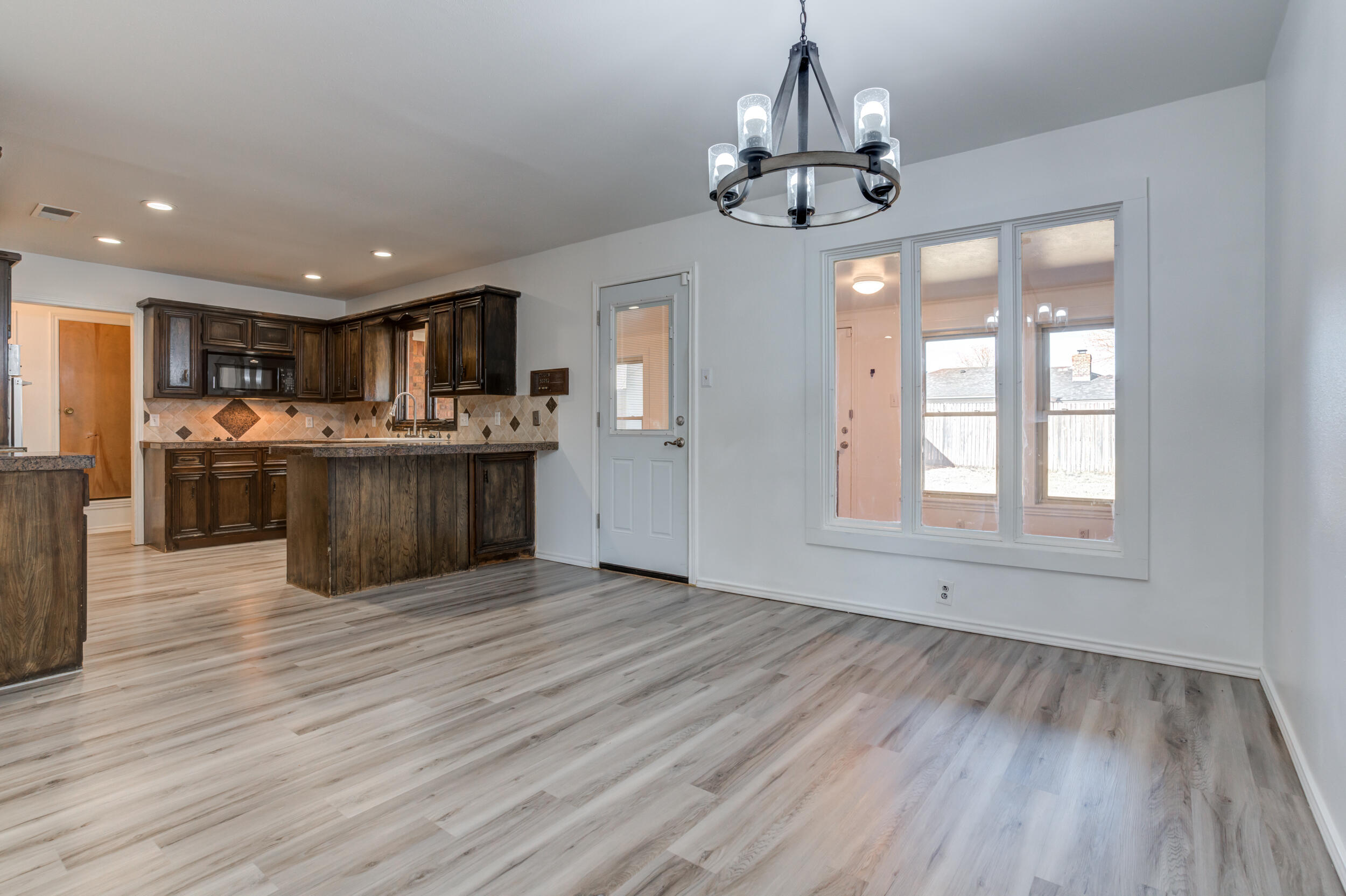 5504 73rd Street Lubbock, TX 79424 - Photo 10 of 39 a view of a kitchen with granite countertop stainless steel appliances and wooden floor