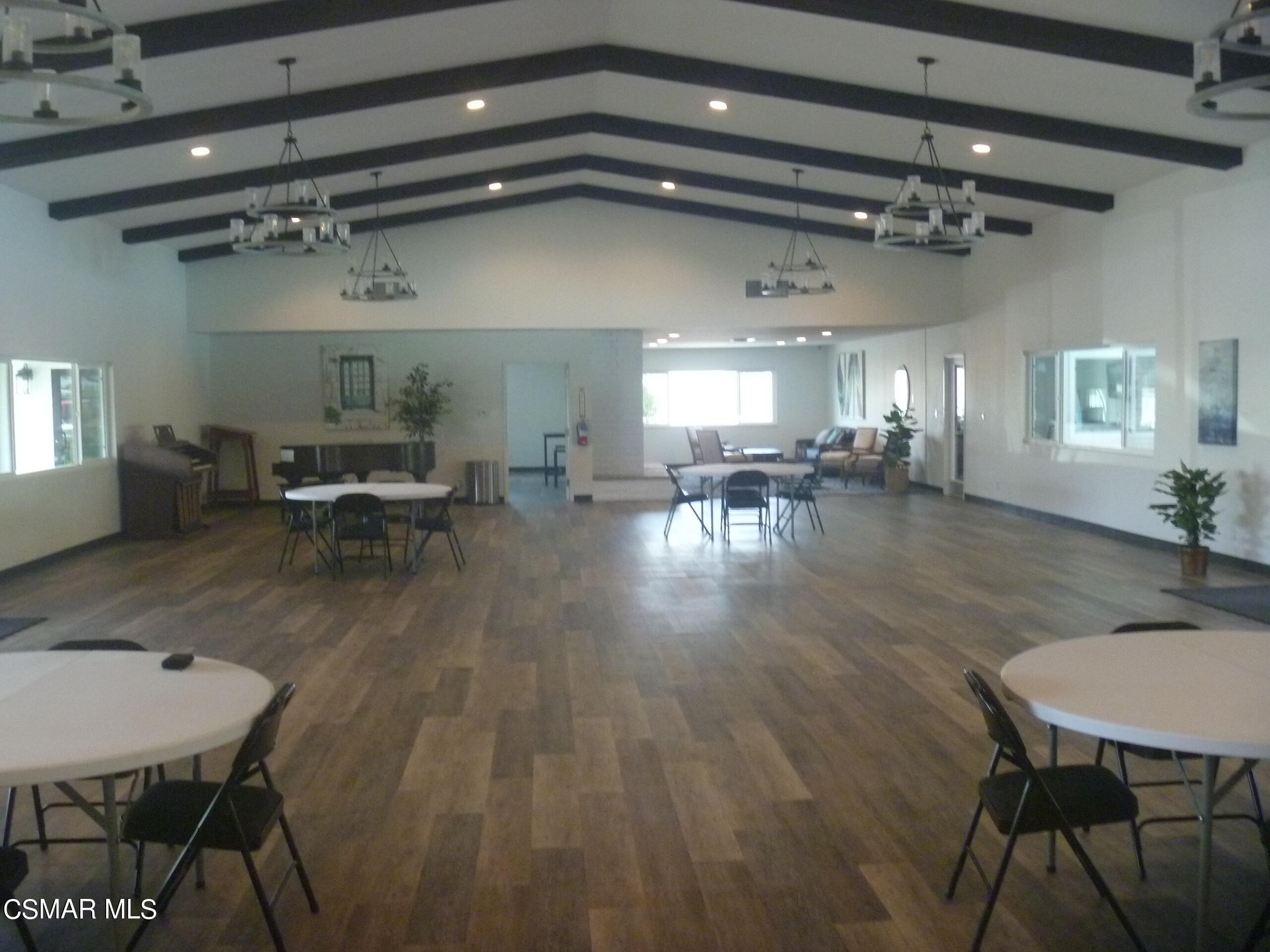 250 East Telegraph Road, Unit 58 Fillmore, CA 93015 - Photo 25 of 29 a dining room with wooden floor a chandelier a wooden table and chairs