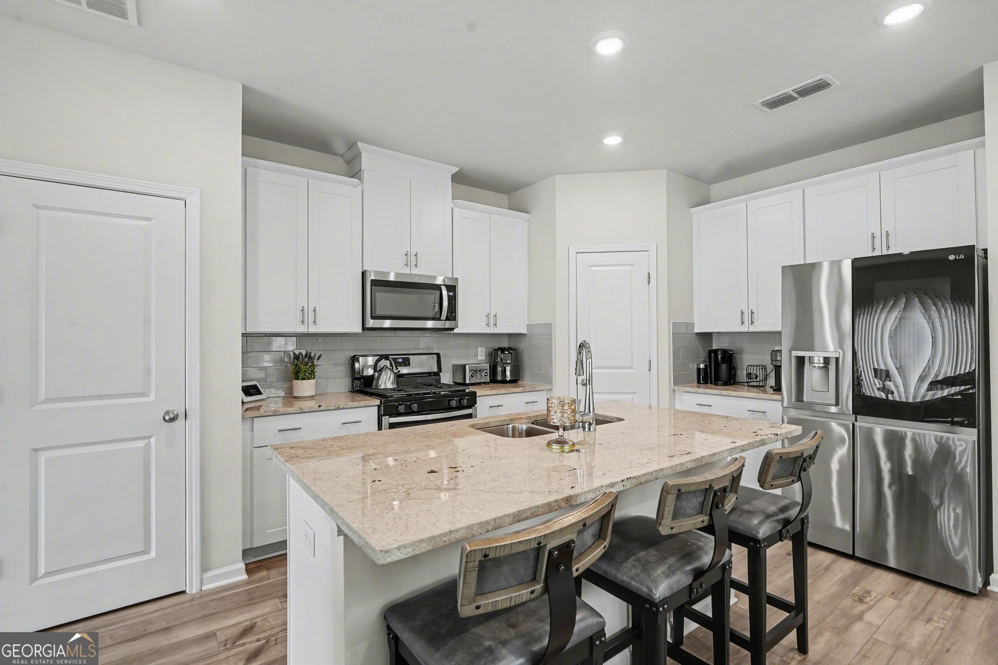 316 Warner Road McDonough, GA 30253 - Photo 4 of 27 a kitchen with stainless steel appliances granite countertop a stove a refrigerator a sink a dining table and chairs