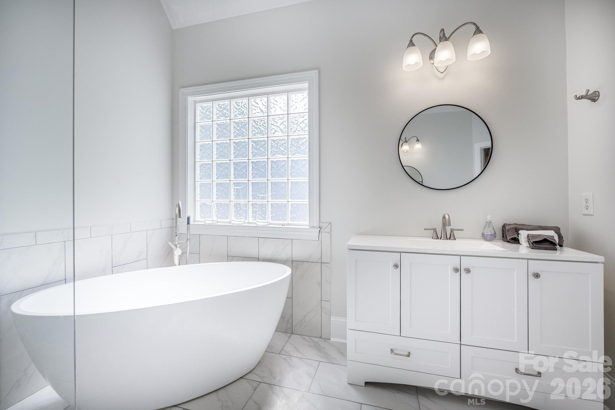 7867 Golf Course Drive North Denver, NC 28037 - Photo 18 of 34 a bathroom with a bathtub a sink and a mirror