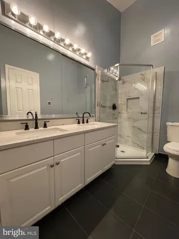 a bathroom with a double vanity sink a toilet and a mirror