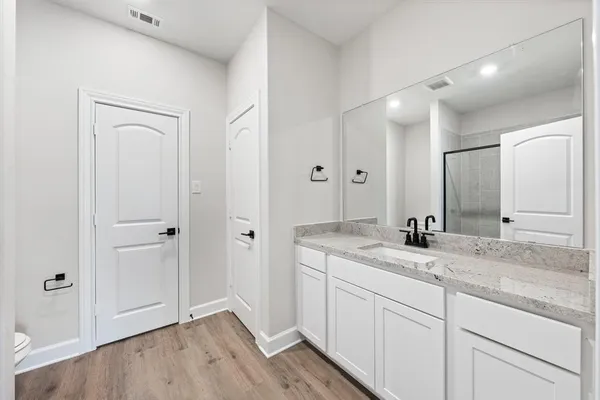 an empty room with wooden floor ceiling fan and windows