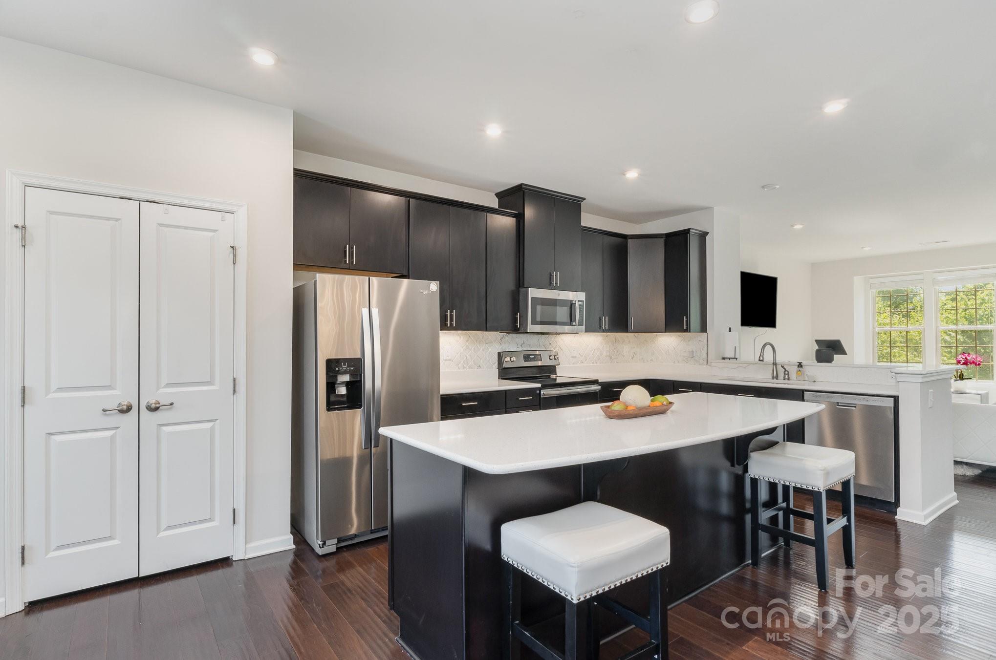 3718 Speer Boulevard Charlotte, NC 28217 - Photo 21 of 48 a kitchen with a table chairs refrigerator and cabinets