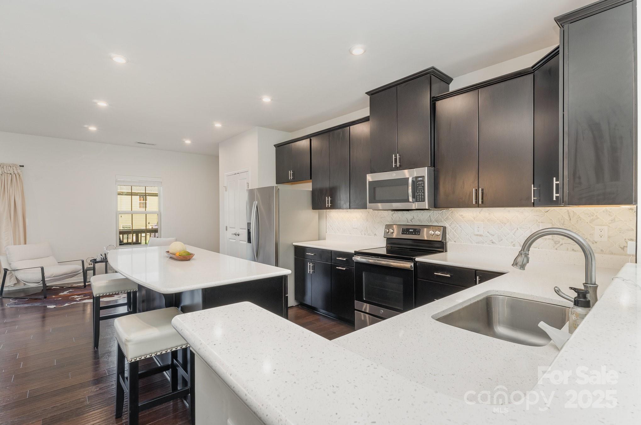 3718 Speer Boulevard Charlotte, NC 28217 - Photo 24 of 48 a kitchen with stainless steel appliances kitchen island granite countertop a sink dishwasher a stove a refrigerator with island and chairs