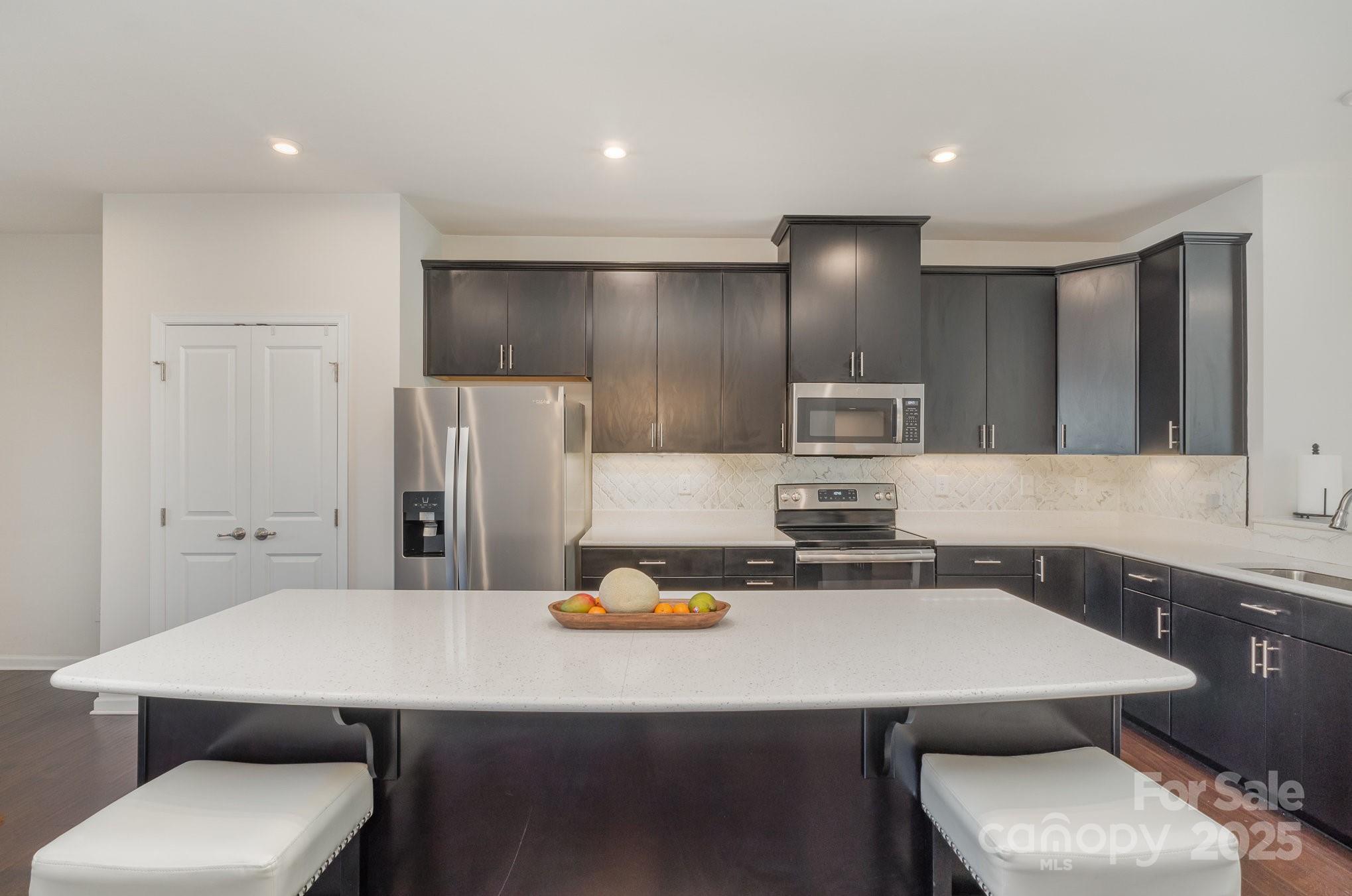 3718 Speer Boulevard Charlotte, NC 28217 - Photo 25 of 48 a kitchen with a table chairs sink and refrigerator