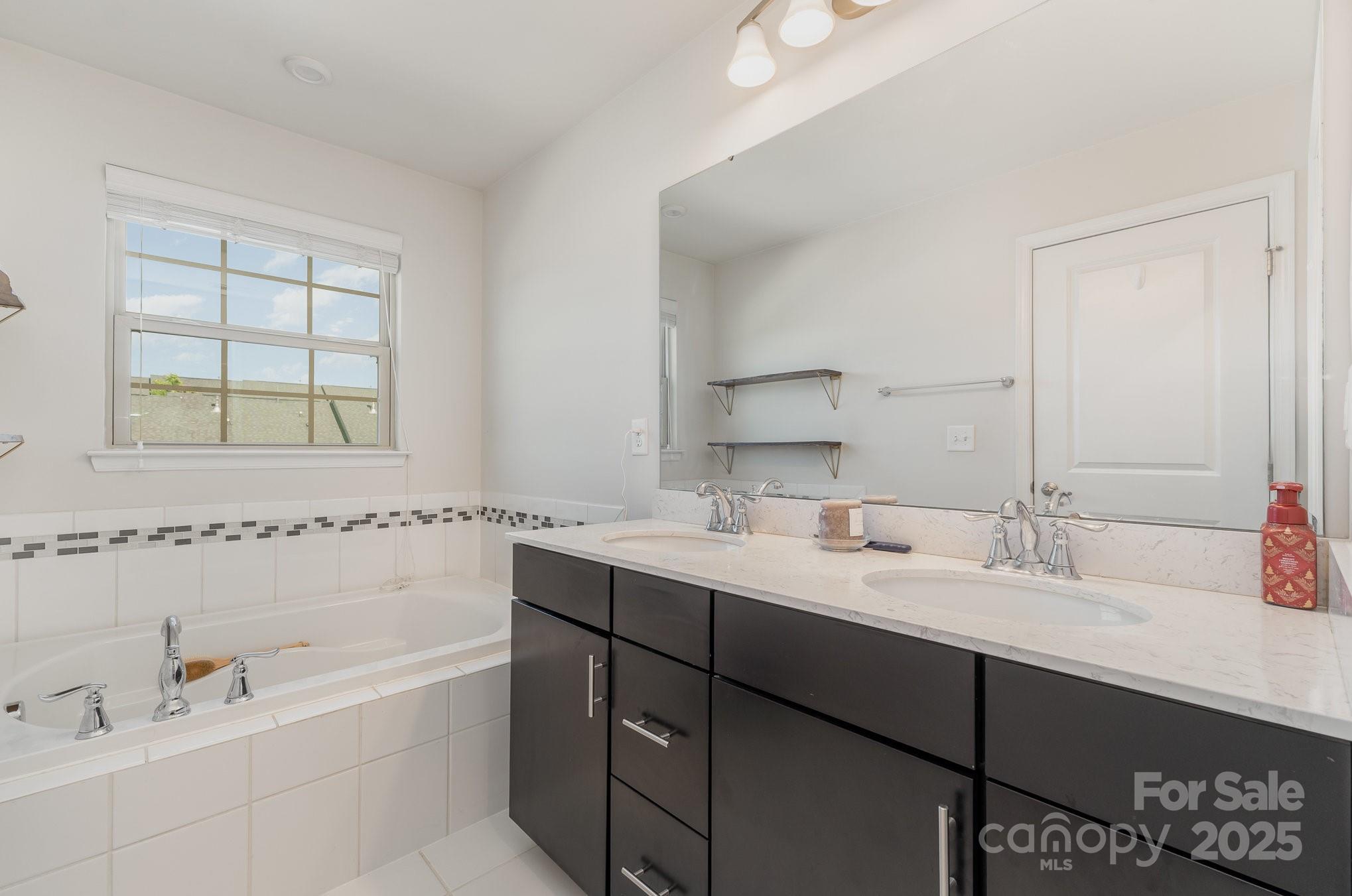 3718 Speer Boulevard Charlotte, NC 28217 - Photo 32 of 48 a bathroom with a tub a sink and mirror