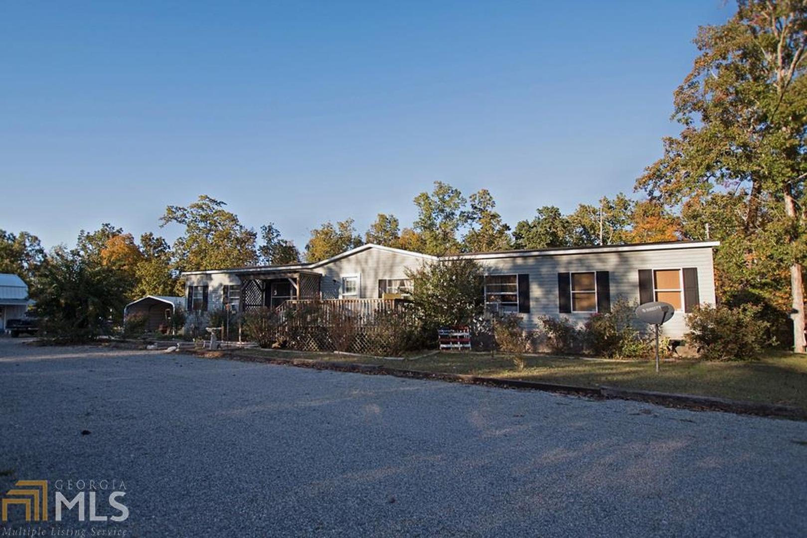 a view of a house with a yard and potted plants