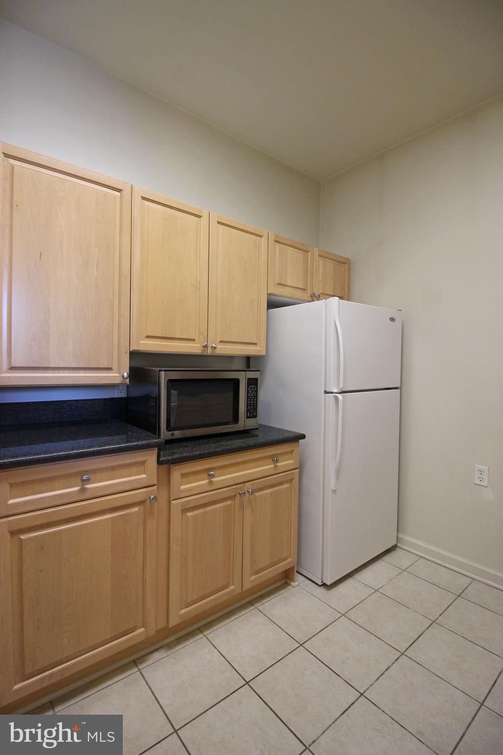 2726 Gallows Road, Unit 112 Vienna, VA 22180 - Photo 3 of 27 a kitchen with a refrigerator and white cabinets