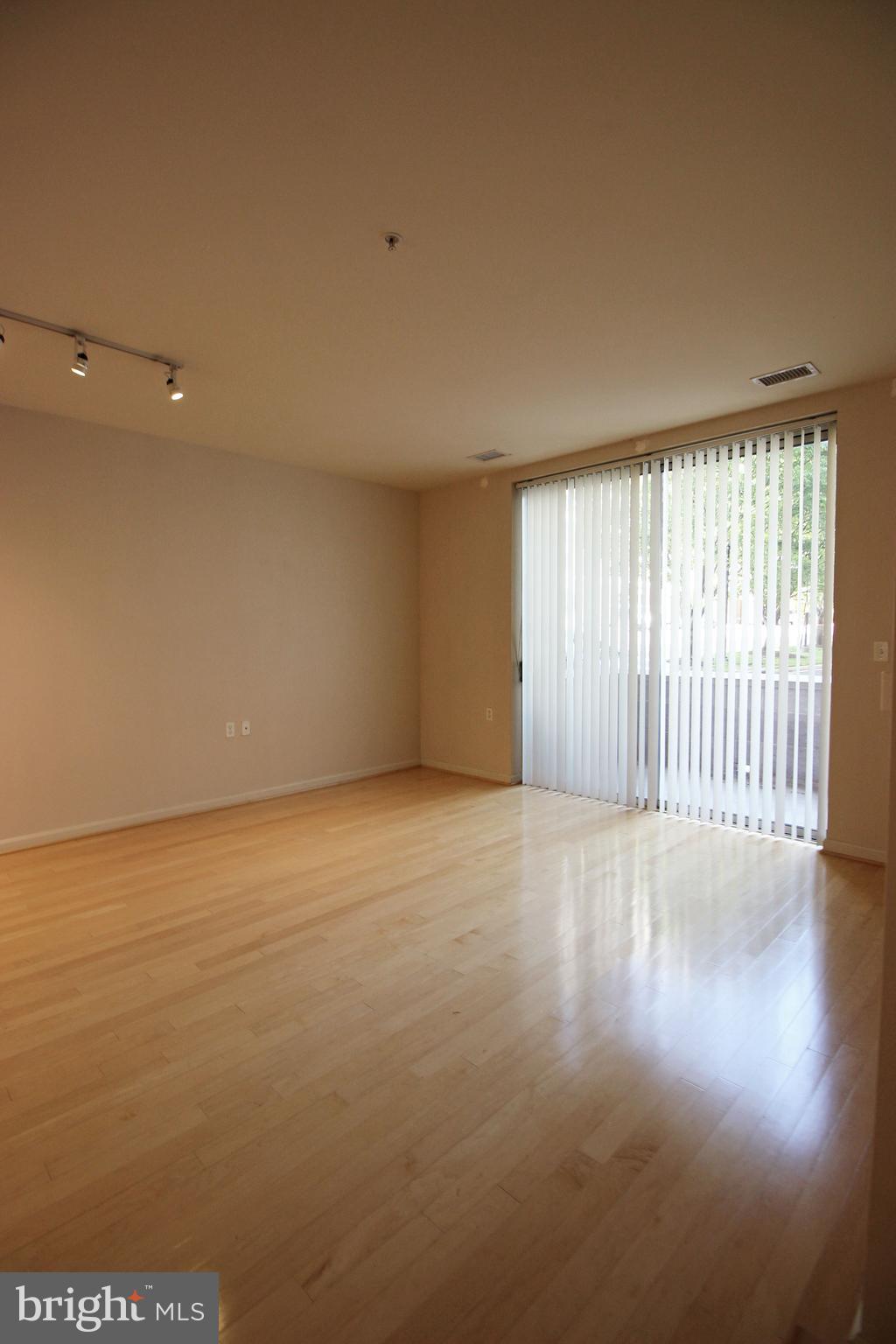 2726 Gallows Road, Unit 112 Vienna, VA 22180 - Photo 7 of 27 wooden floor in an empty room with a window