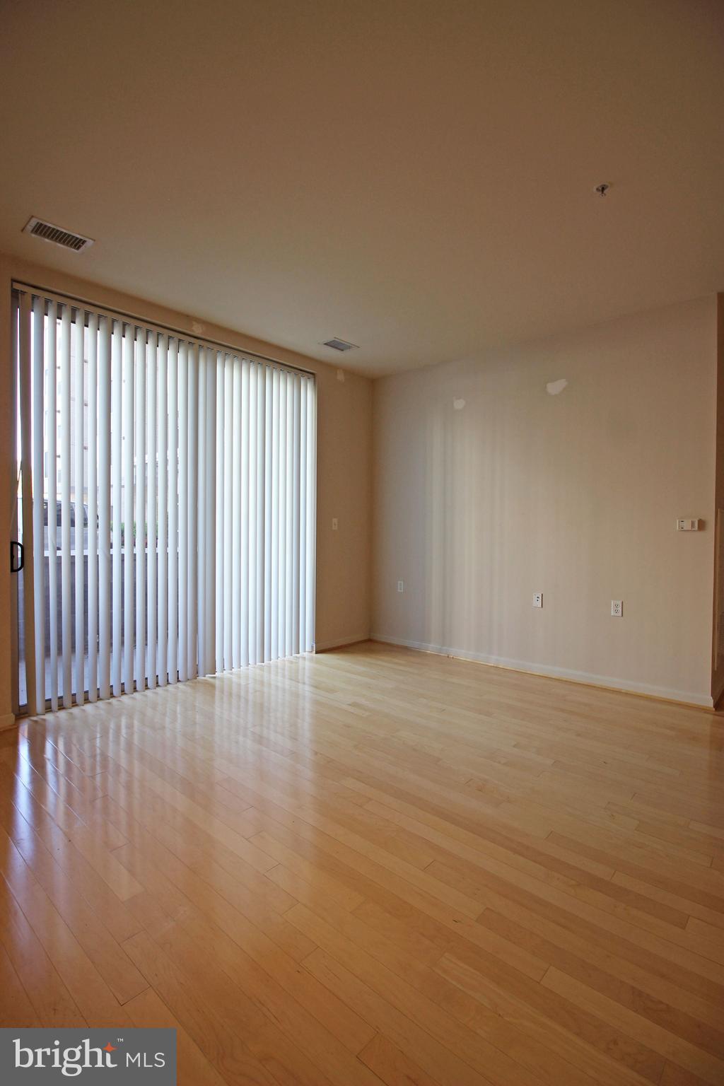 2726 Gallows Road, Unit 112 Vienna, VA 22180 - Photo 8 of 27 a view of an empty room with wooden floor and a window