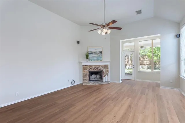 a view of an empty room with a window and fireplace