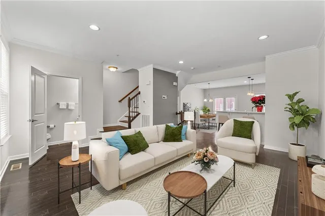 a living room with furniture kitchen view and a potted plant