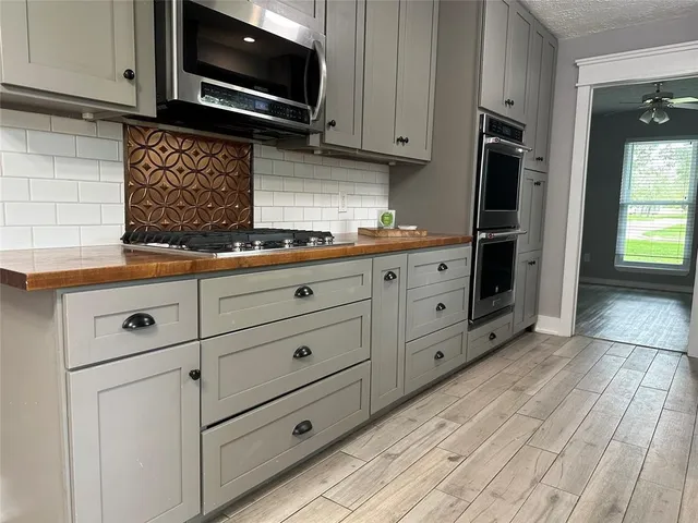 a kitchen with granite countertop white cabinets stainless steel appliances and sink