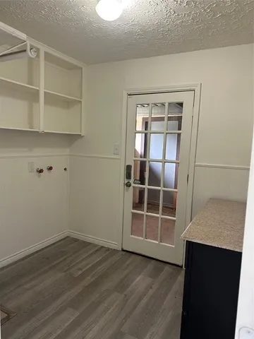 an empty room with wooden floor and cabinet