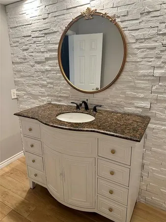 a bathroom with a granite countertop sink and a mirror