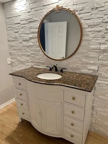 a bathroom with a granite countertop sink and a mirror