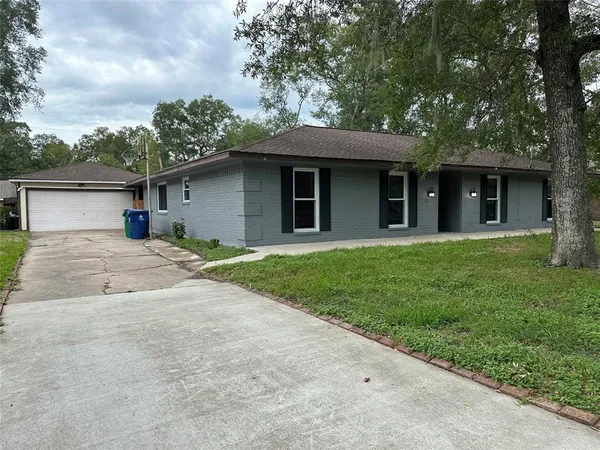 front view of a house with a yard and potted plants