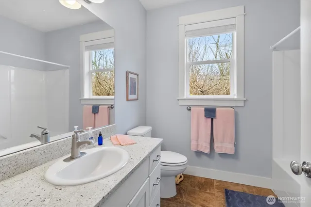 a bathroom with a sink toilet and a window