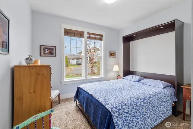 a bedroom with a bed and a dresser next to a window