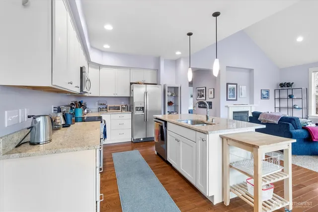 a kitchen with counter top space a sink appliances and cabinets