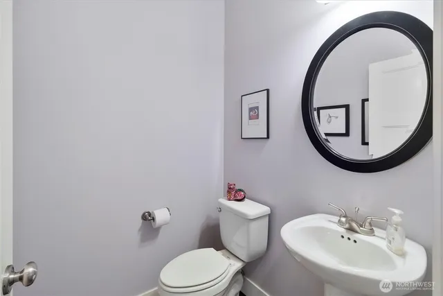 a bathroom with a toilet a sink and a mirror