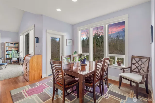a view of a dining room with furniture wooden floor and a potted plant