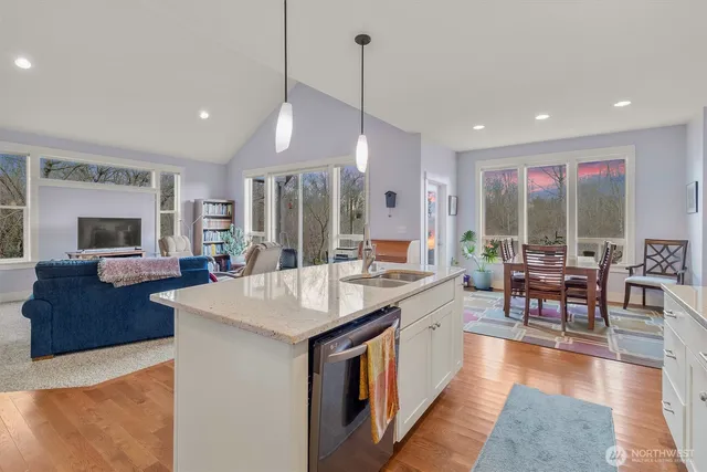 a large kitchen with kitchen island a island a sink a stove and a large refrigerator