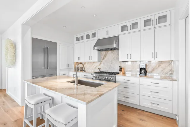 a kitchen with granite countertop a sink cabinets and stainless steel appliances