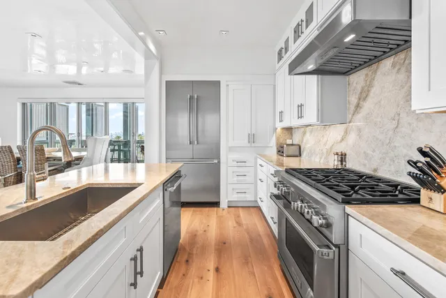 a kitchen with granite countertop a sink stove and cabinets