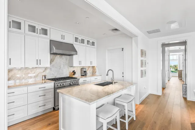 a kitchen with granite countertop a sink stove and cabinets