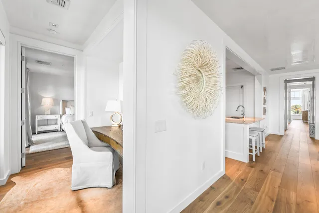 a view of a hallway with furniture and wooden floor